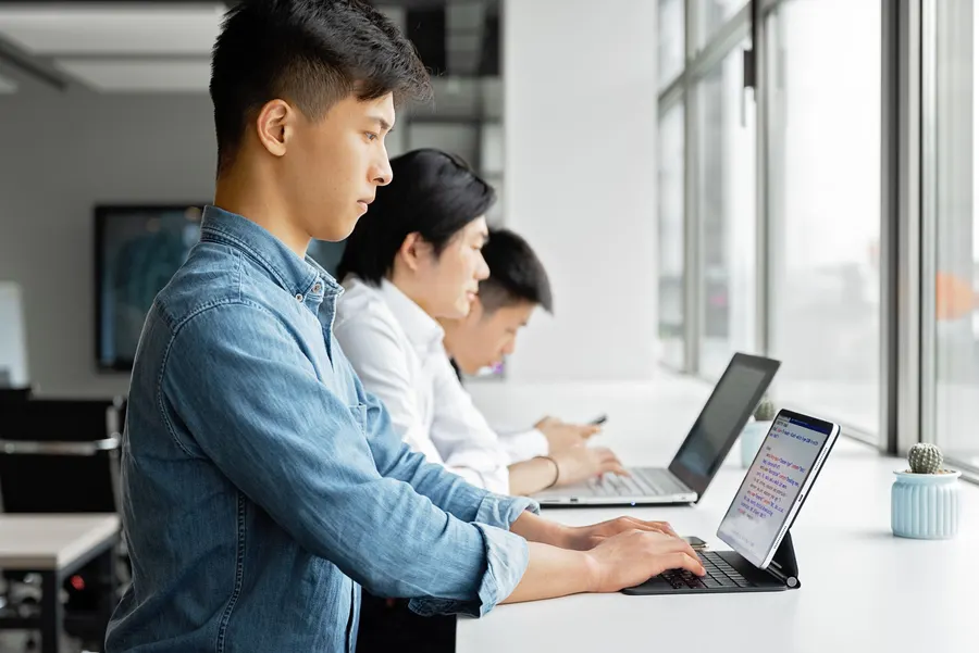 Tim pengembang bekerja dengan laptop di kantor